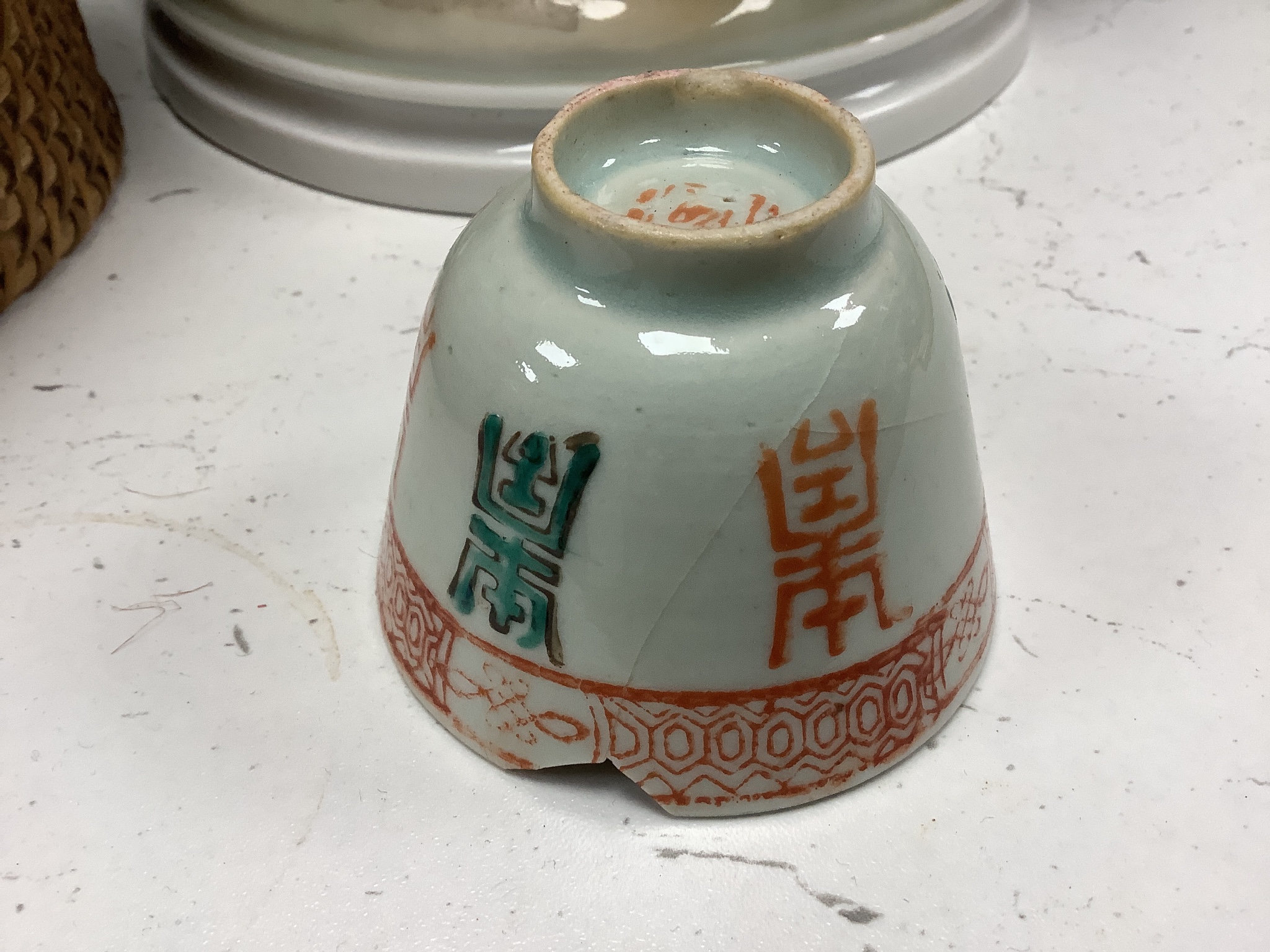 A Chinese teapot and two tea bowls, in carrying basket